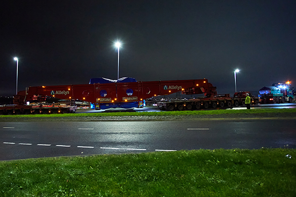An Allelys trailor transporting a turbine at night