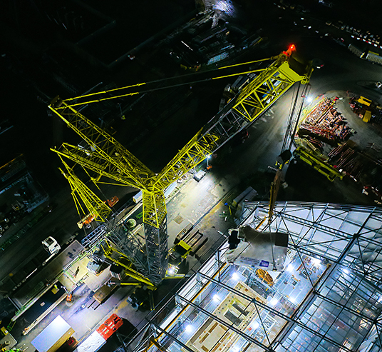 Aerial image of a generator being lifted into a warehouse via the ceiling by an Allelys heavy lift crane